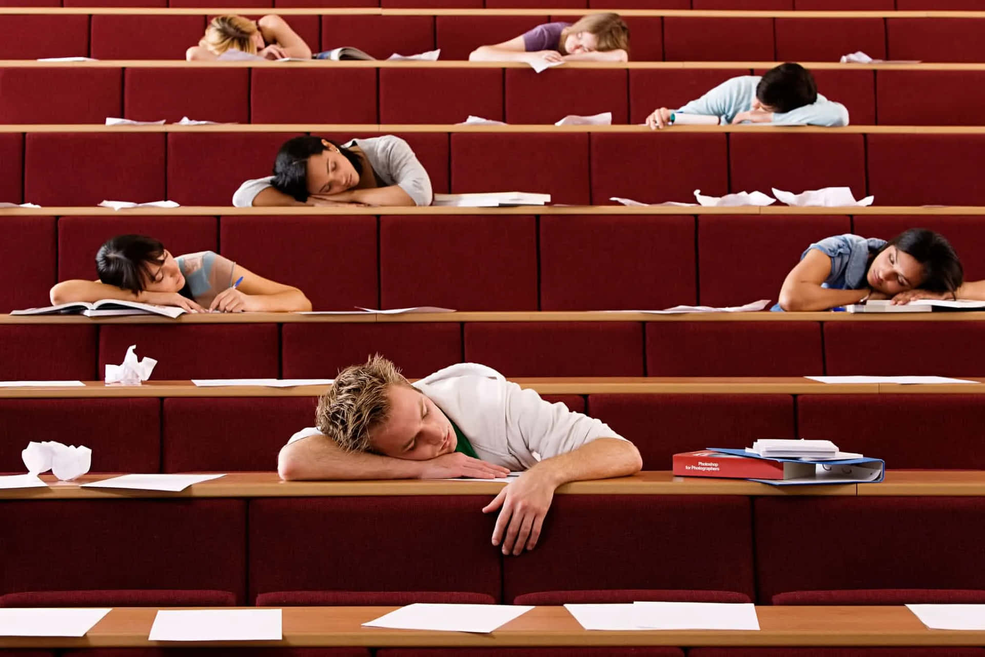 A Group Of People Sleeping In A Lecture Hall