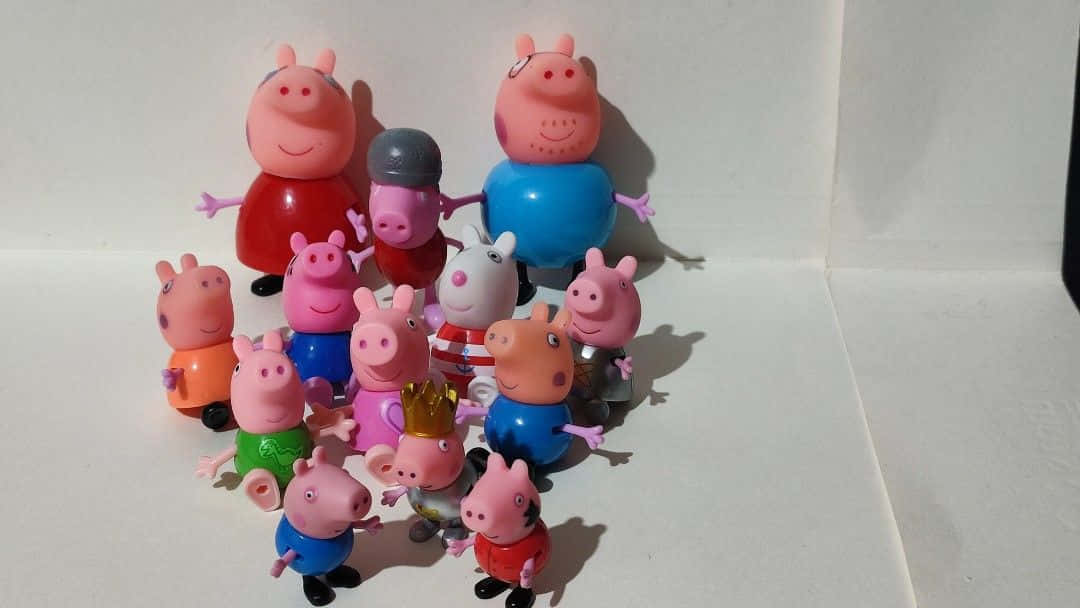 Peppa Pig, George Pig, and their parents, Mummy and Daddy Pig, smile together as a family.