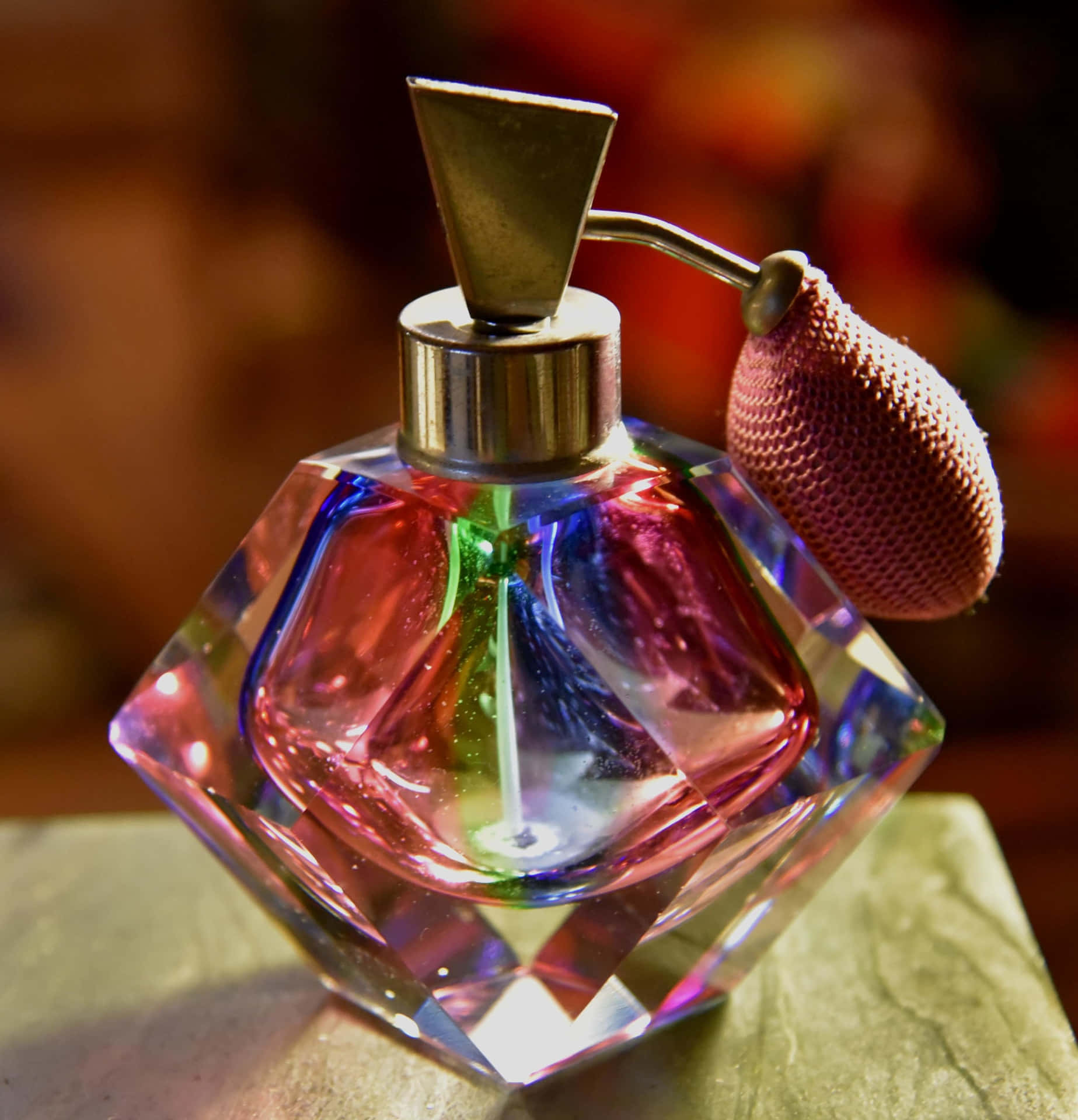 A Small Bottle Of Perfume With A Pink And Purple Lid