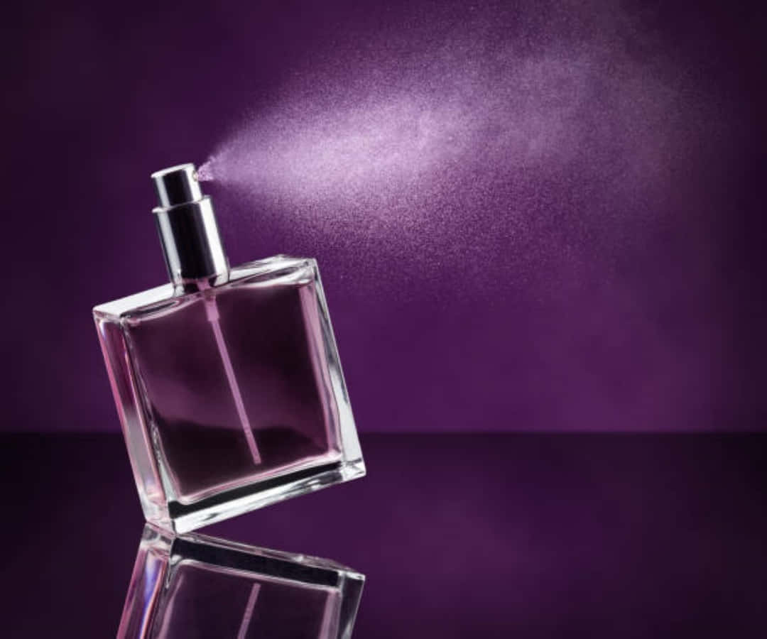 A Perfume Bottle With A Spray Of Perfume On A Purple Background