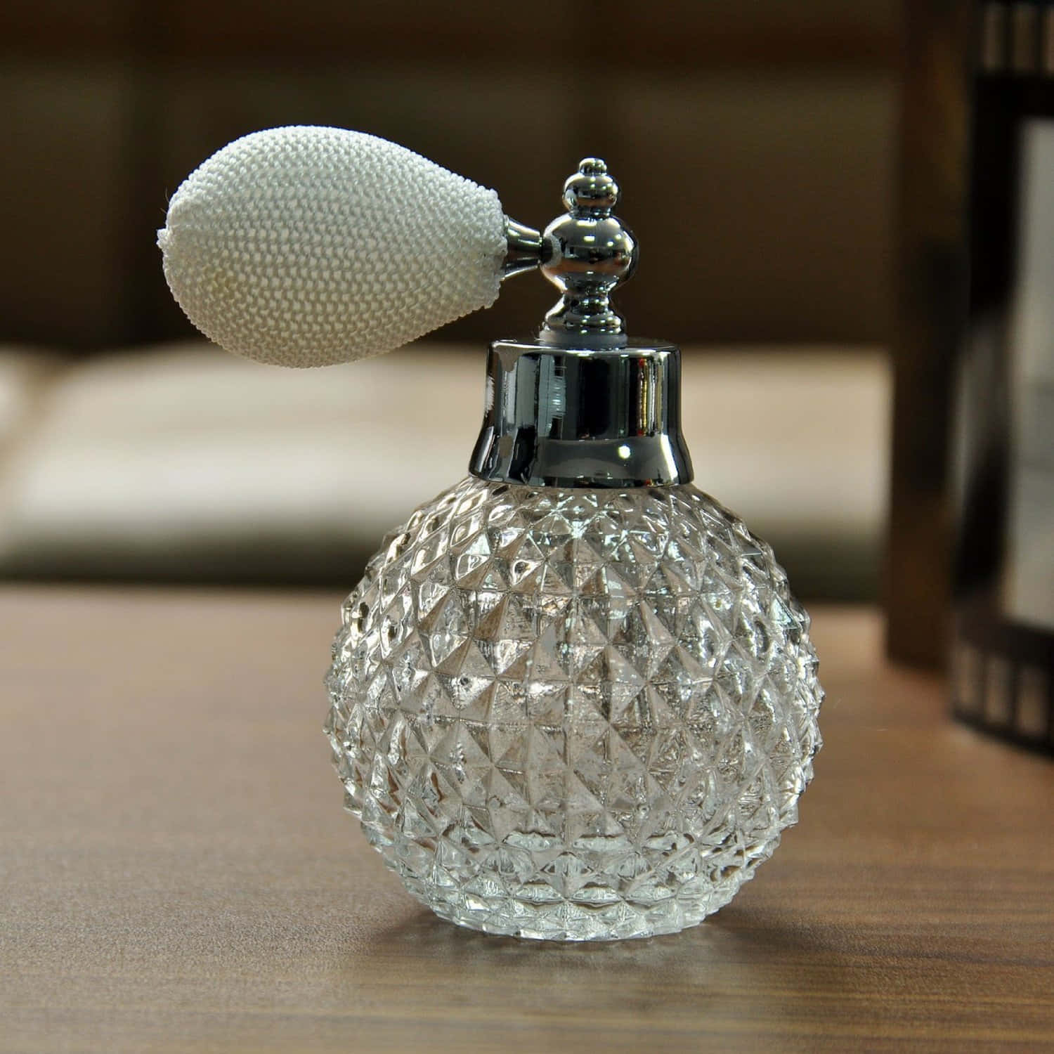 A Glass Perfume Bottle On A Table