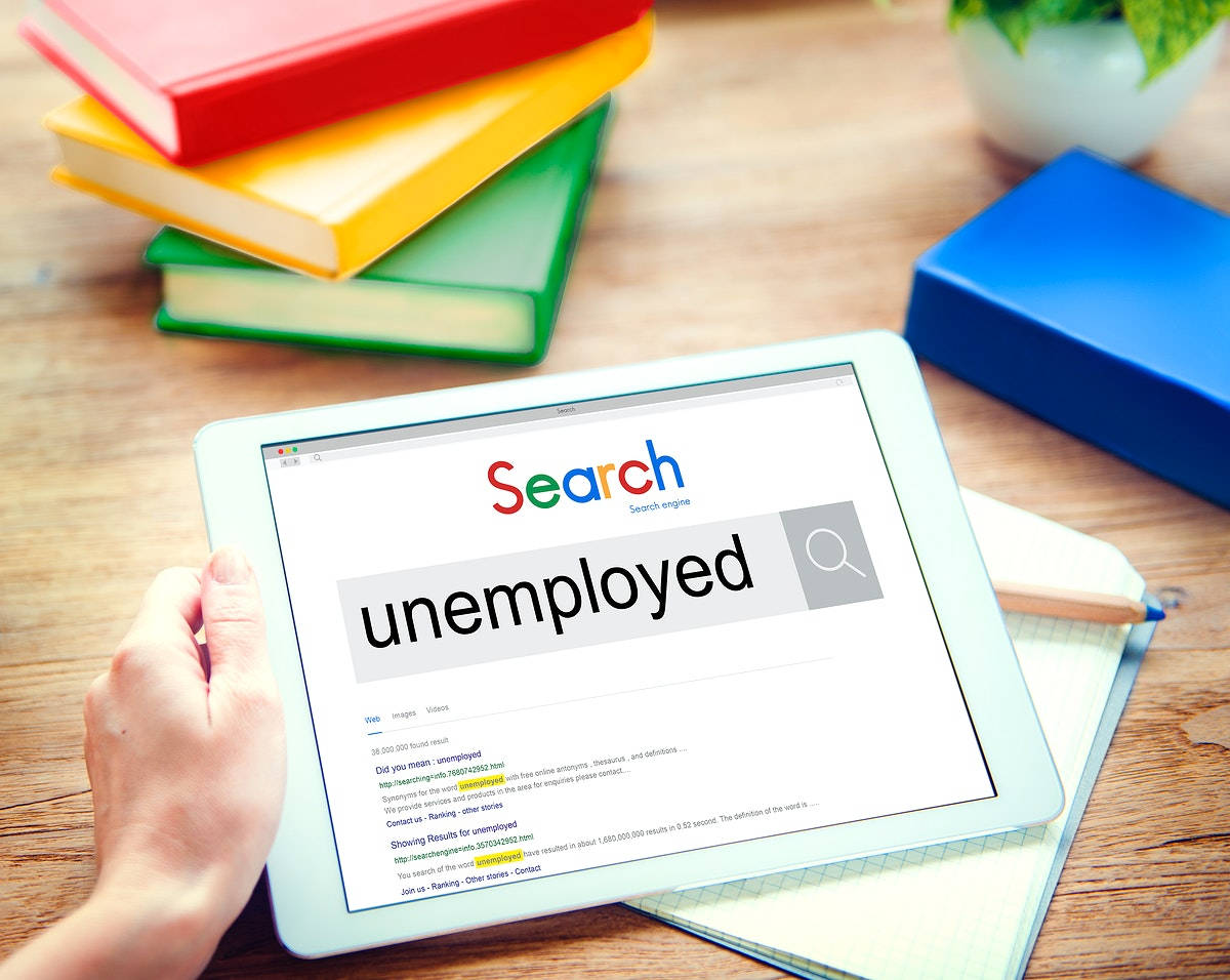 En person, der søger efter arbejdsløshed ved hjælp af en tablet. Wallpaper