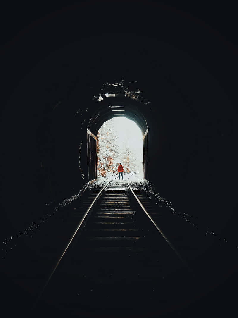 Person Walking Outof Dark Tunnel Wallpaper