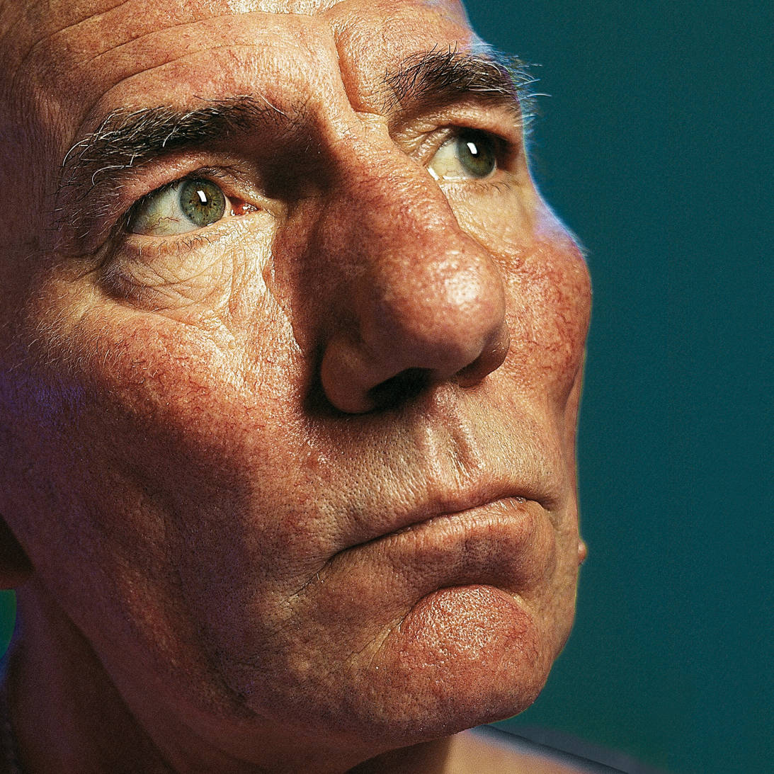 Pete Postlethwaite Looking Up With Green Eyes Wallpaper