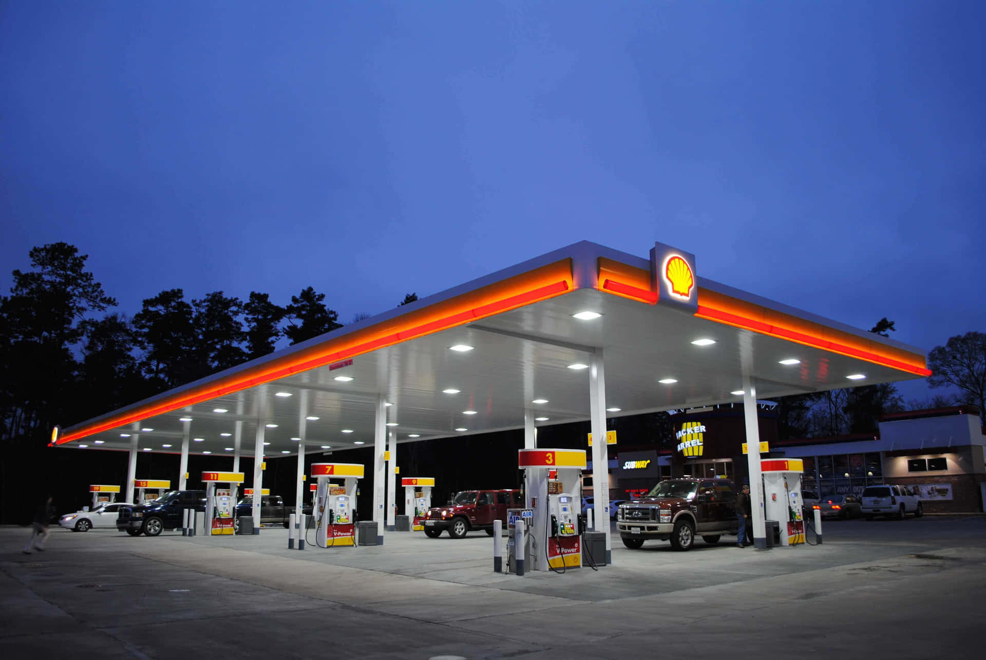 A Gas Station With Cars Parked At Night