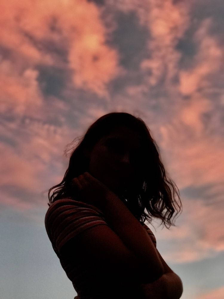 PFP Aesthetic Girl Under Cloudy Sunset Sky Wallpaper