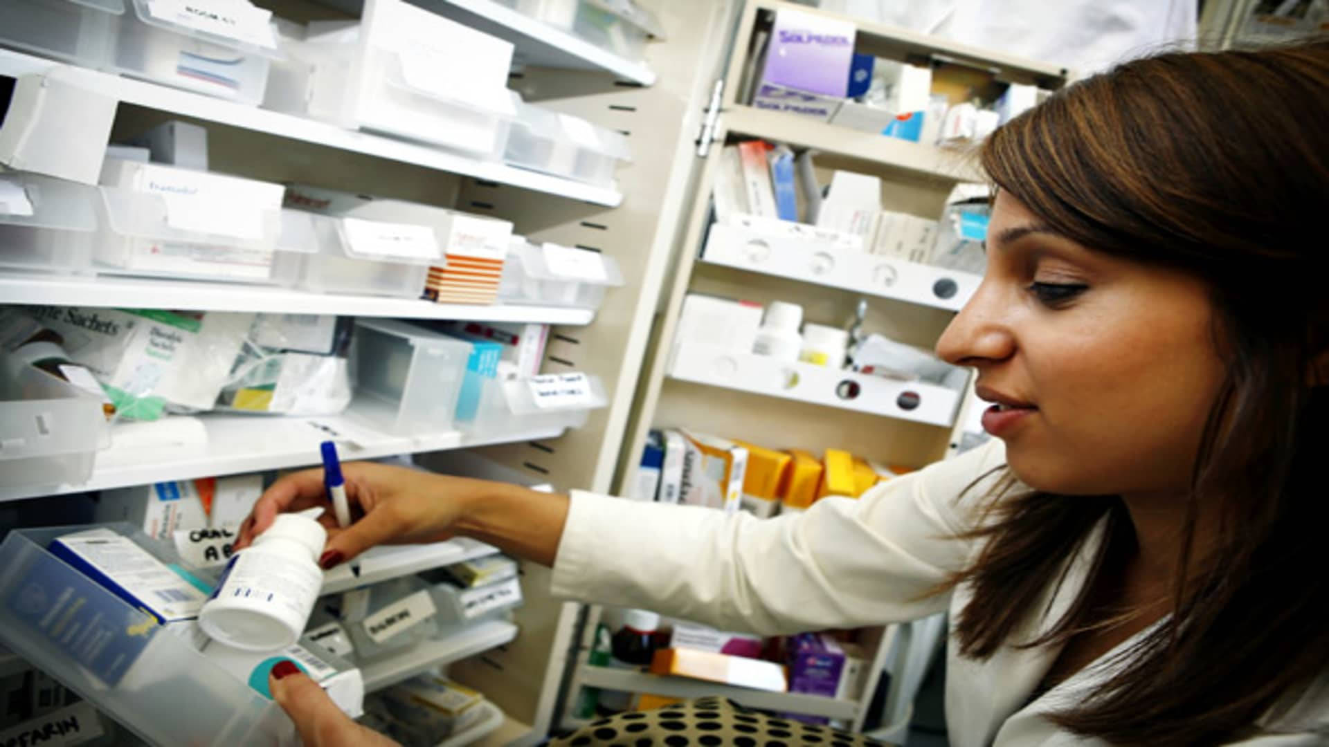 Pharmacist Checking A Medicine Bottle Wallpaper