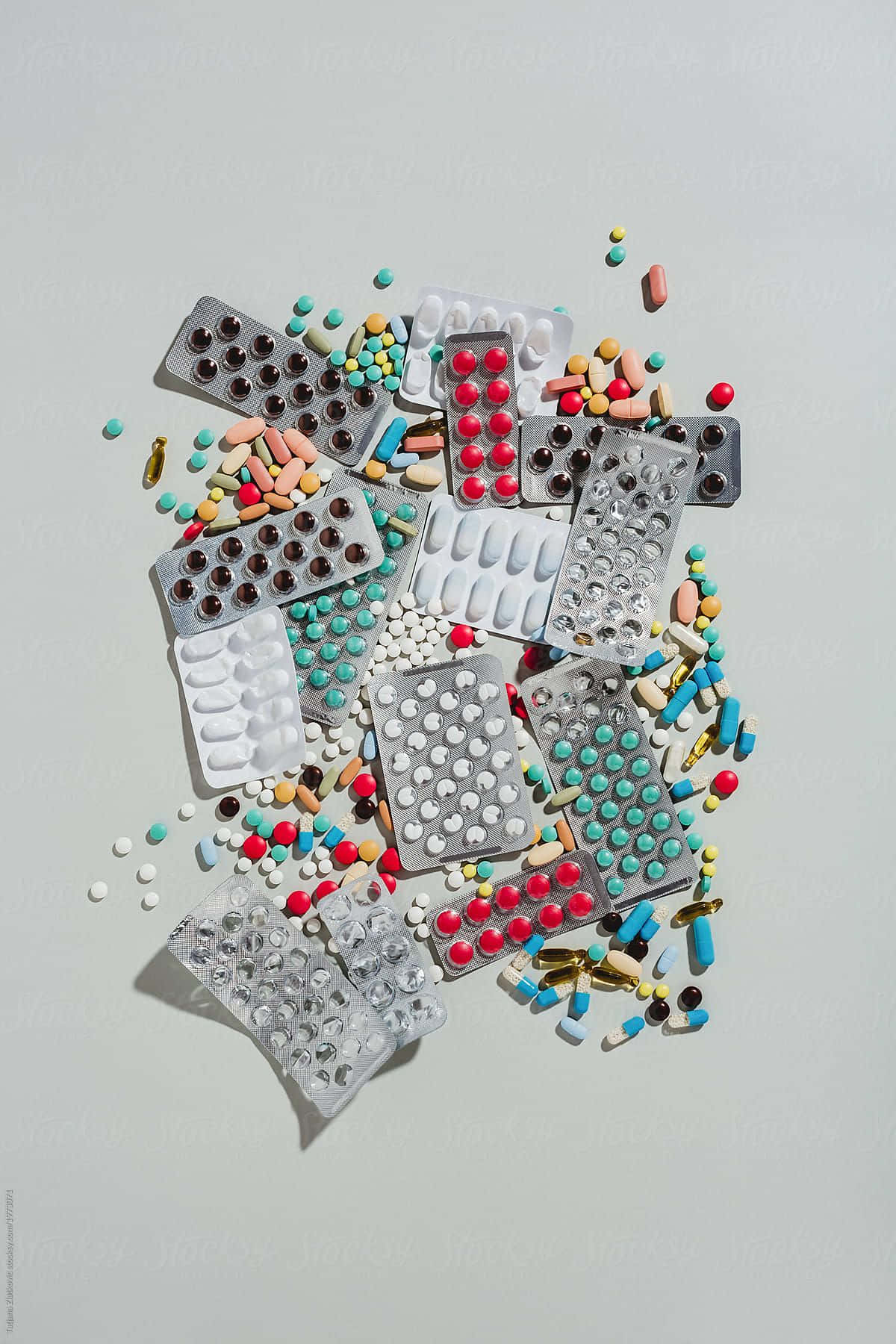 A Pile Of Pills And Tablets On A White Surface