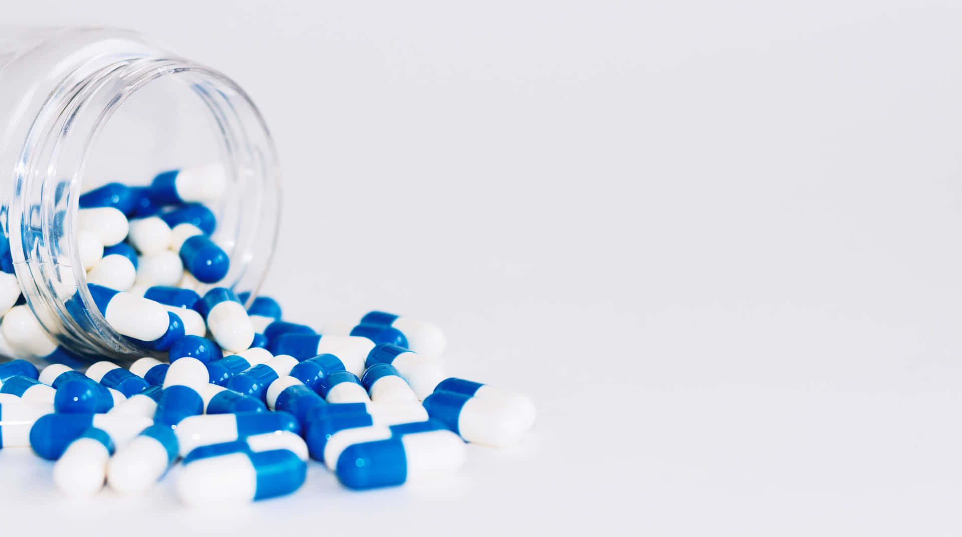 A Glass Jar With Blue And White Pills