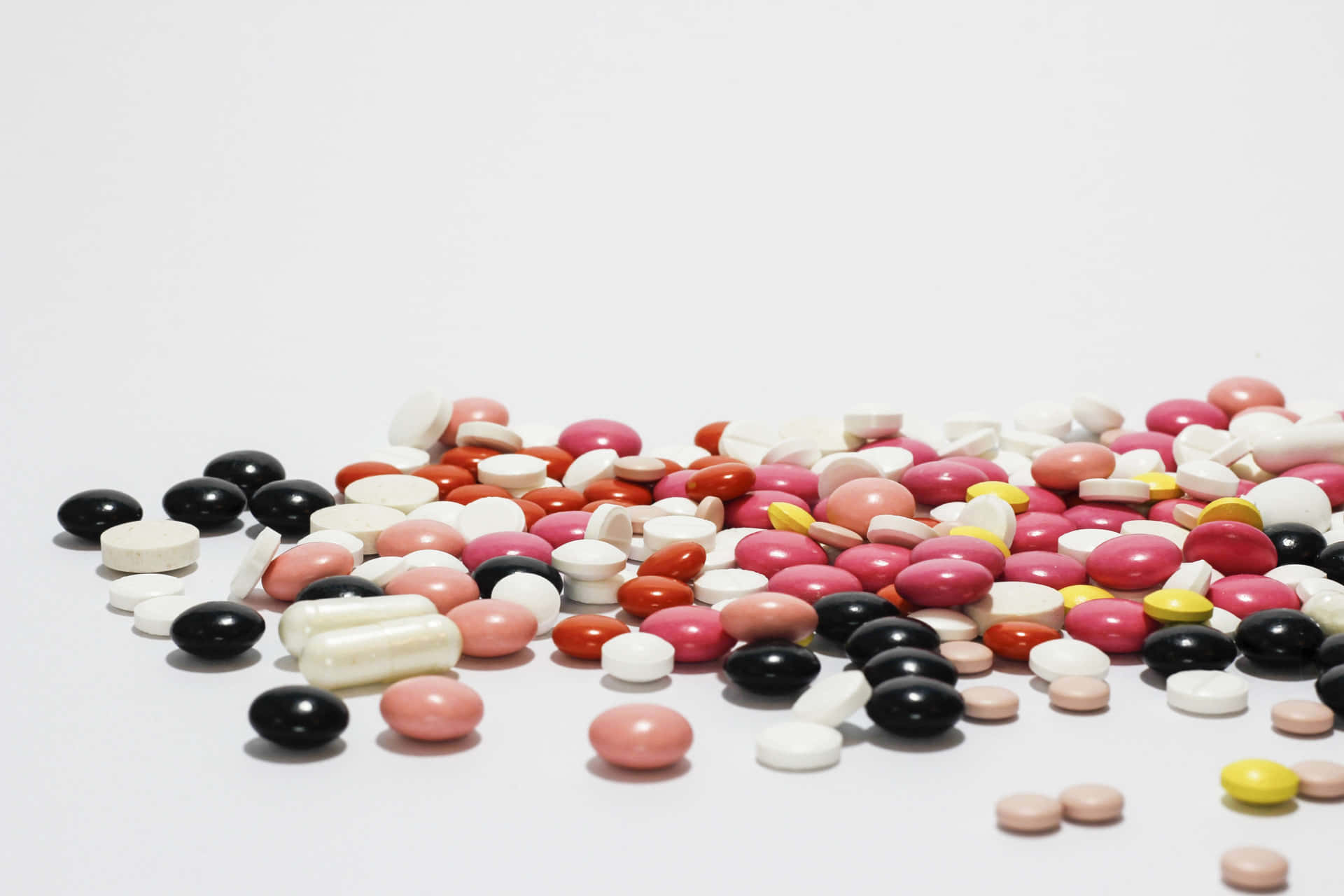 A Pile Of Pills On A White Surface