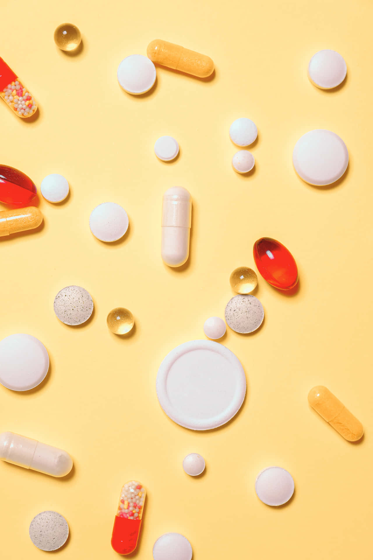 A Group Of Pills And Tablets On A Yellow Background