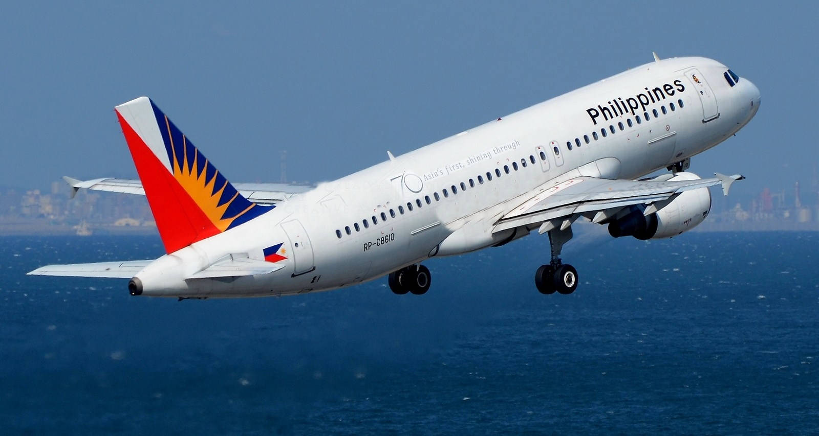 Philippineairlines Flyger Över Havet - In The Context Of Computer Or Mobile Wallpaper, This Could Potentially Be A Great Scenic Wallpaper Featuring Philippine Airlines Flying Over The Sea. Wallpaper