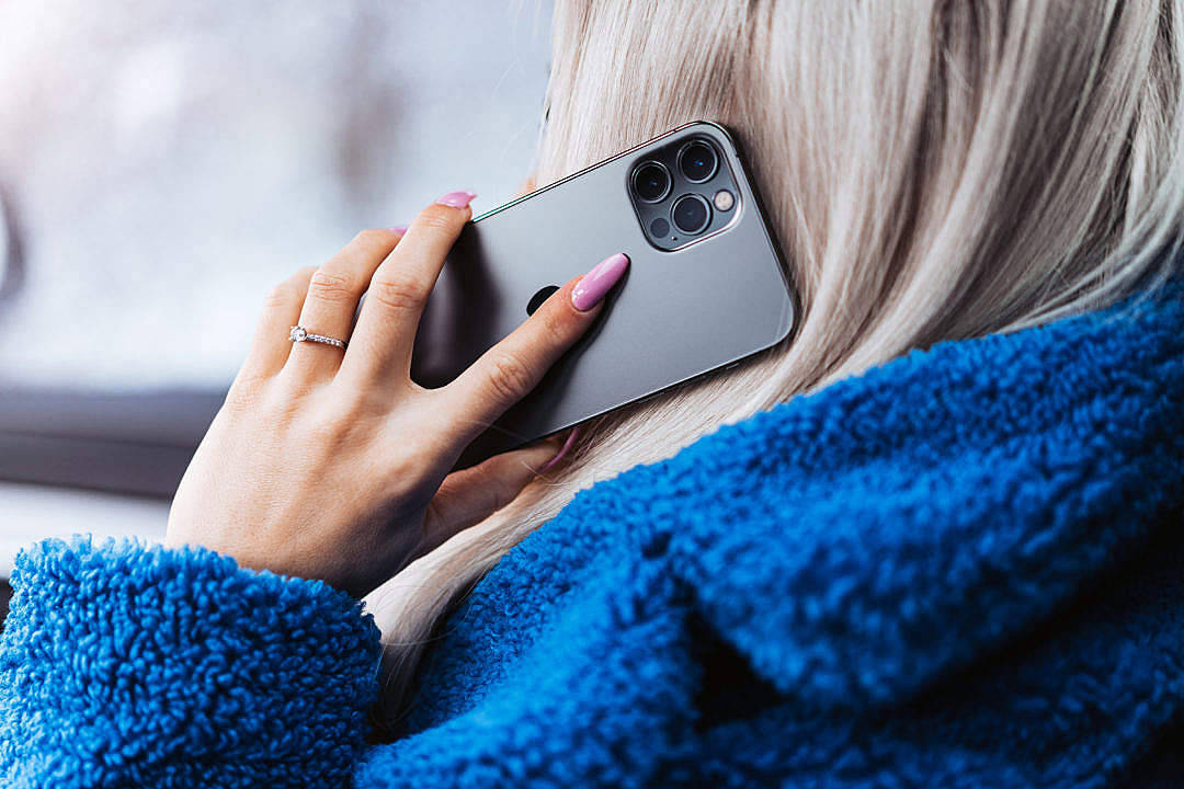 Llamadatelefónica De Una Mujer Con Un Suéter Azul Y Esponjoso. Fondo de pantalla
