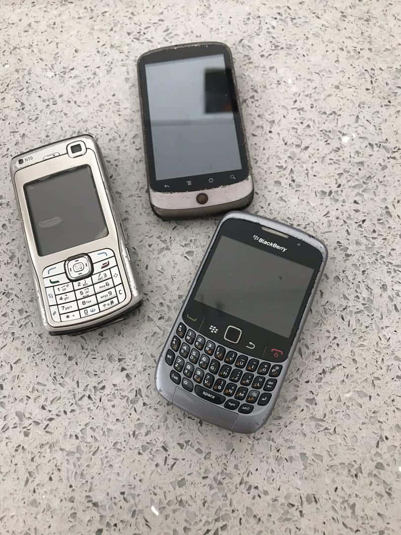 Tre sorte hindbær telefoner på en beton gulv