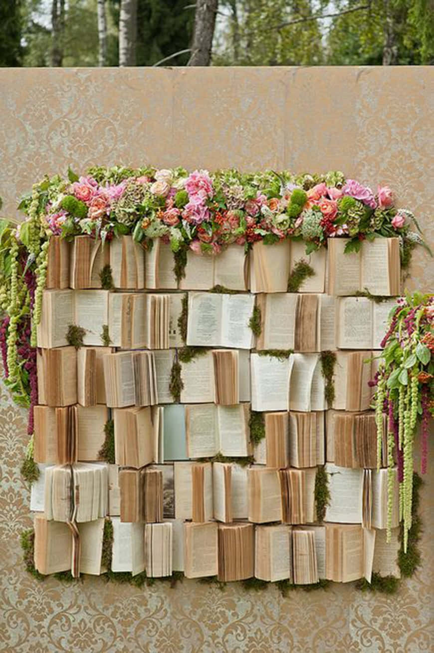 A Wedding Reception With A Book Wall And Flowers