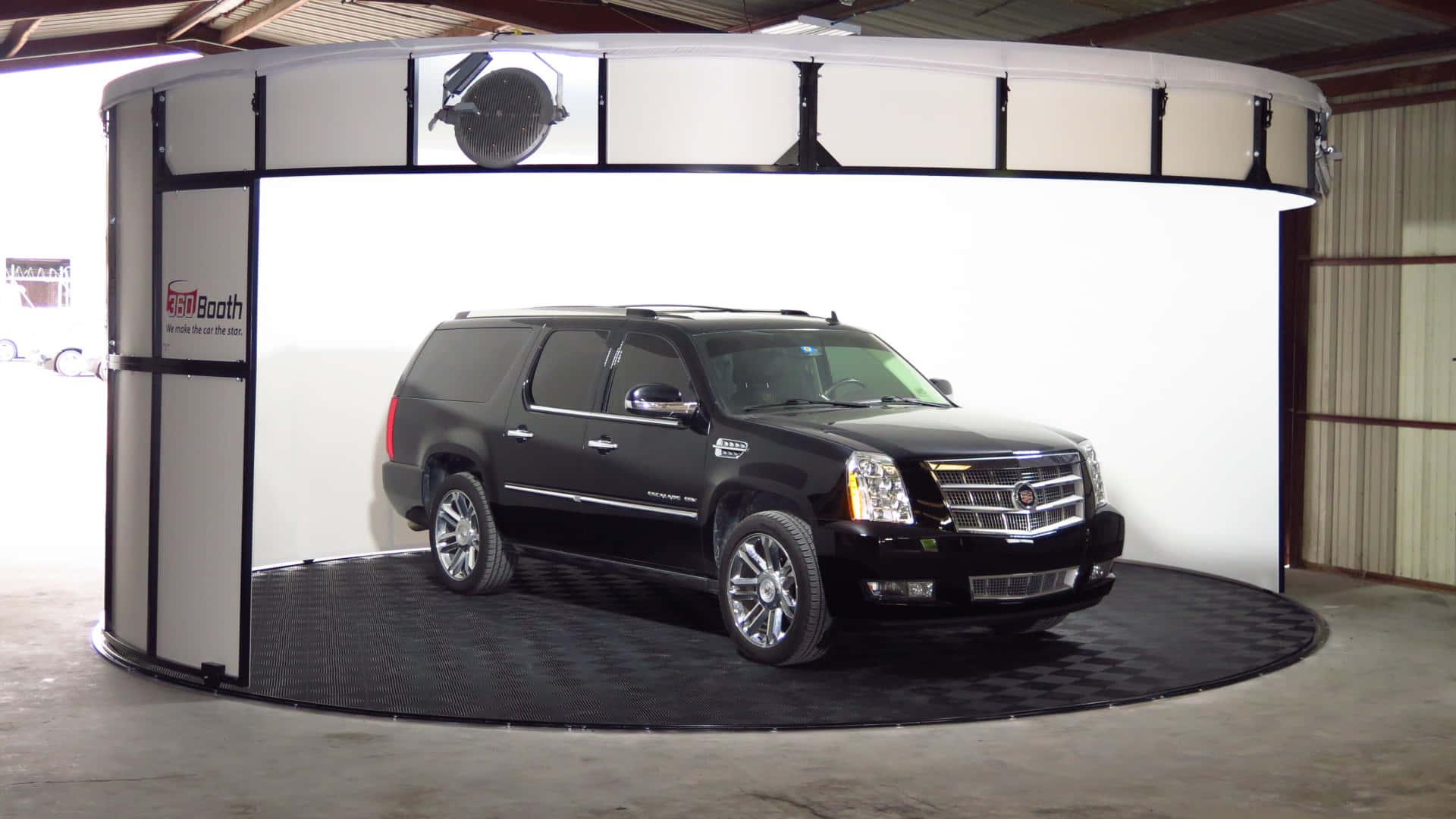 A Black Suv Is In A Circular Booth