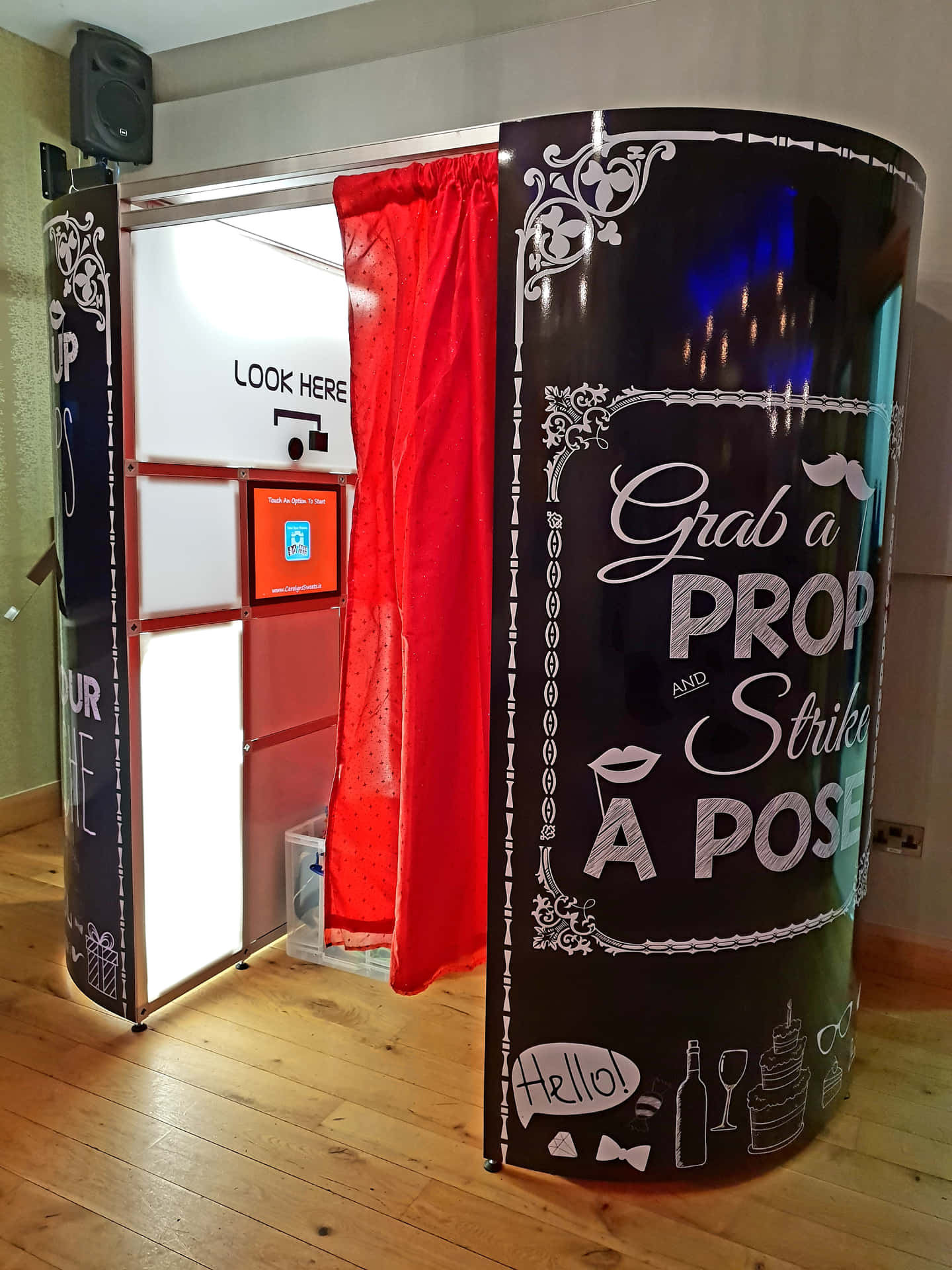 A Photo Booth With A Red Curtain And Black Frame