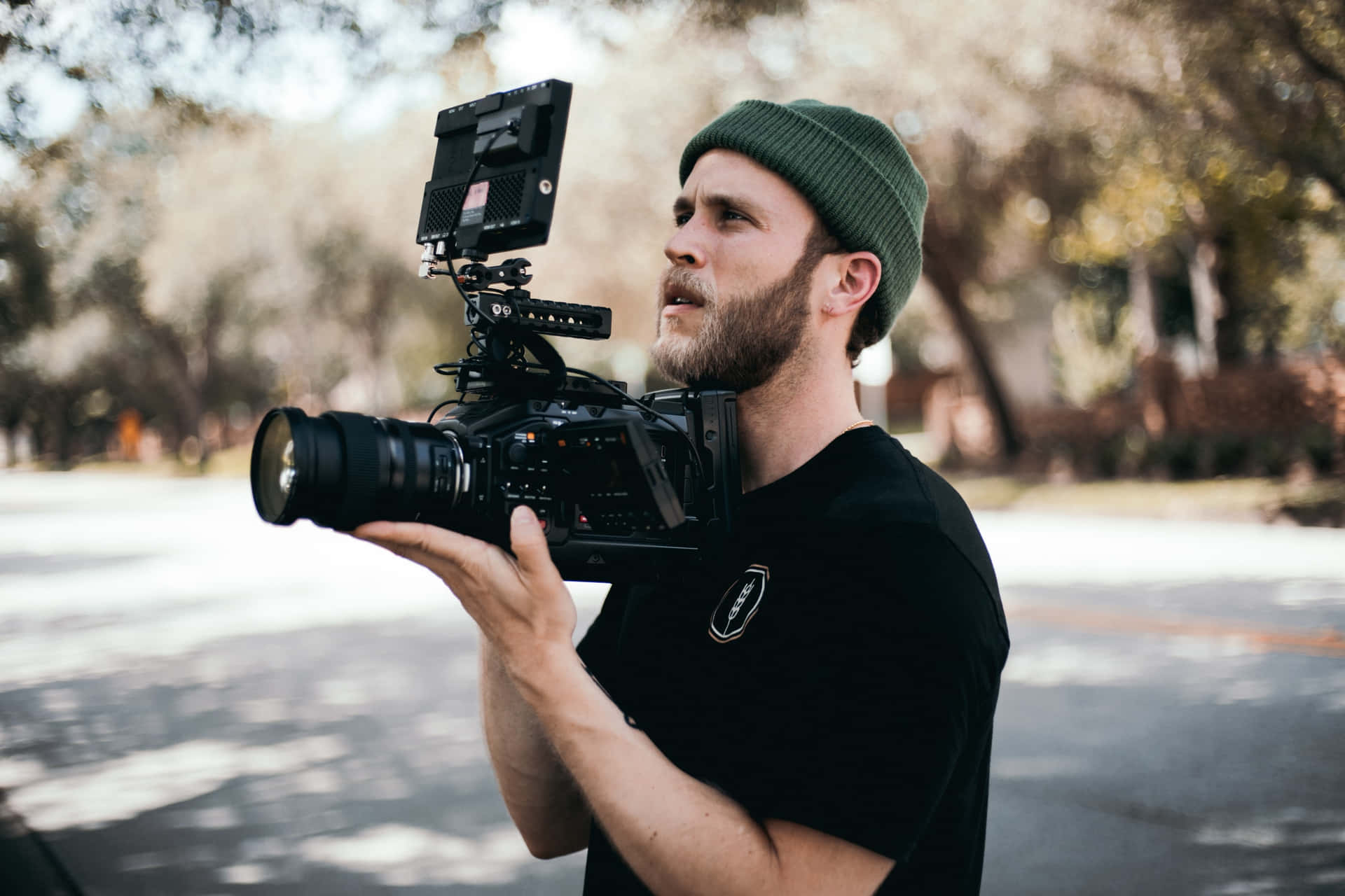 A Man Holding A Camera In Front Of A Tree