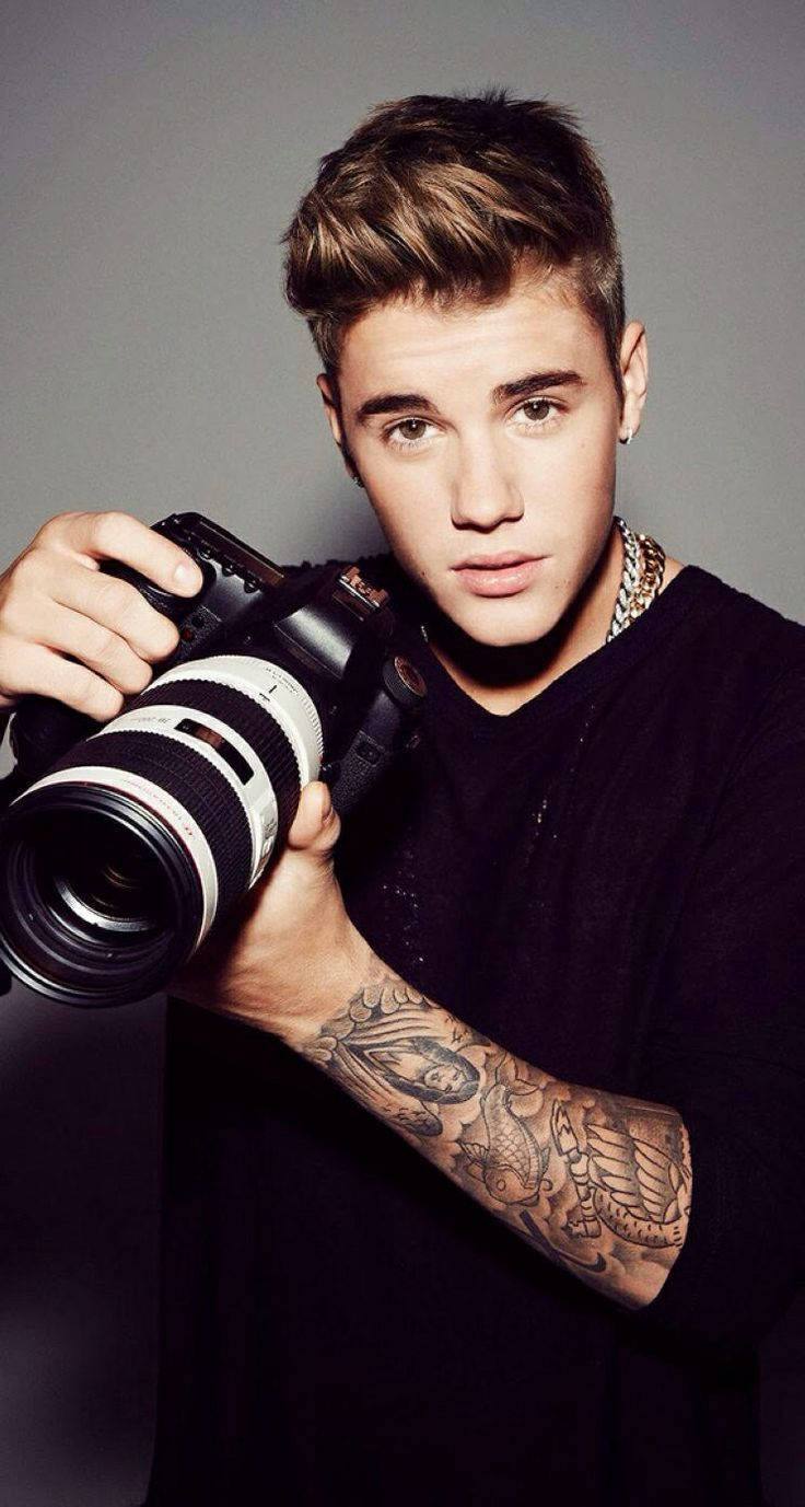 Justin Bieber smiles brightly in a close-up portrait Wallpaper