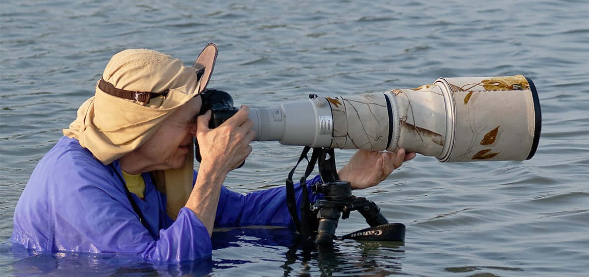 Einefrau Mit Einem Hut Macht Fotos Im Wasser.