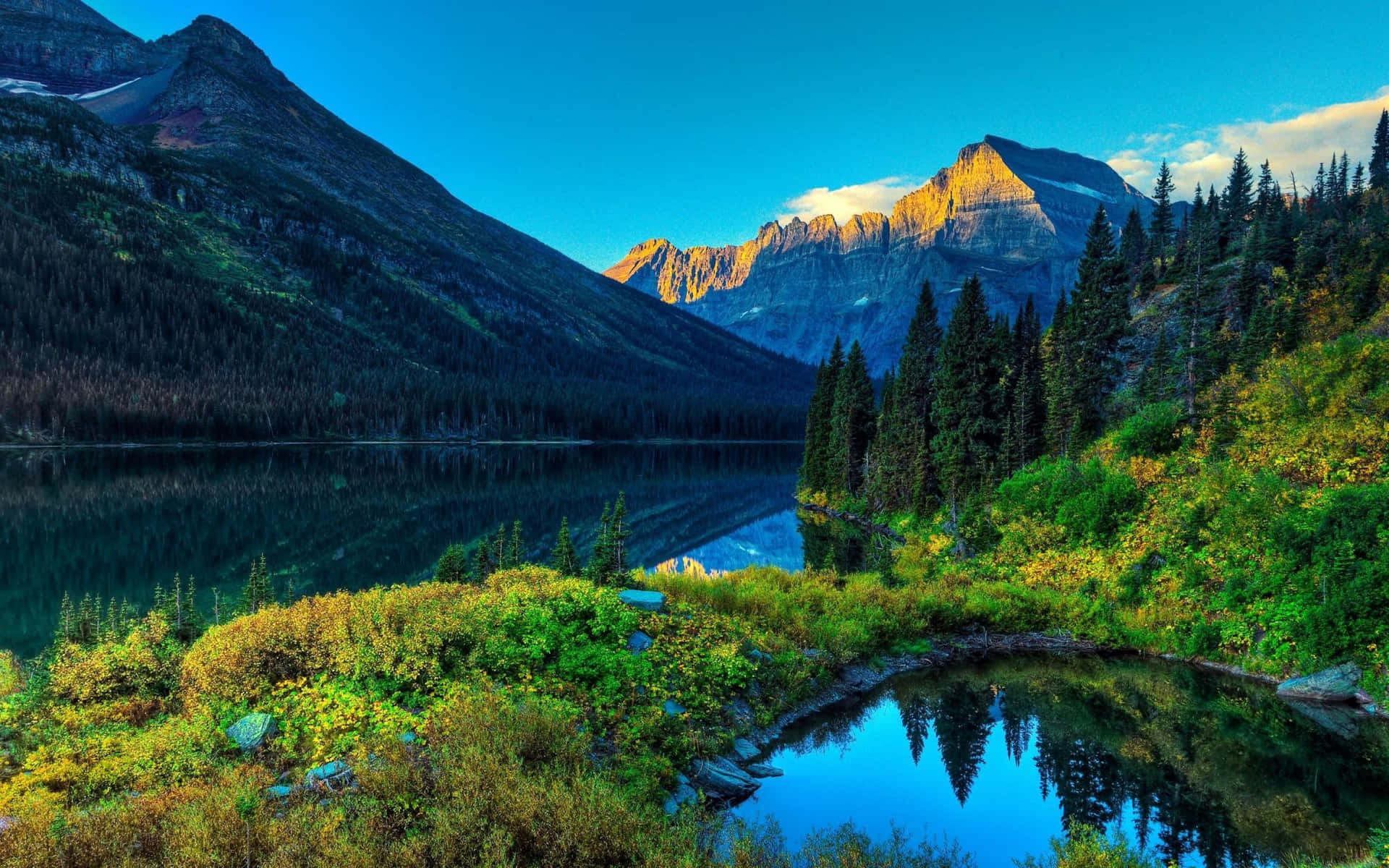 A Lake Surrounded By Mountains And Trees