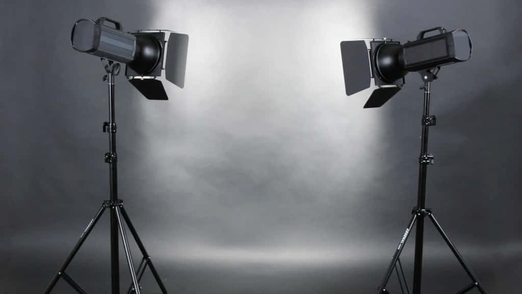 Two Studio Lights On Tripods With A Dark Background