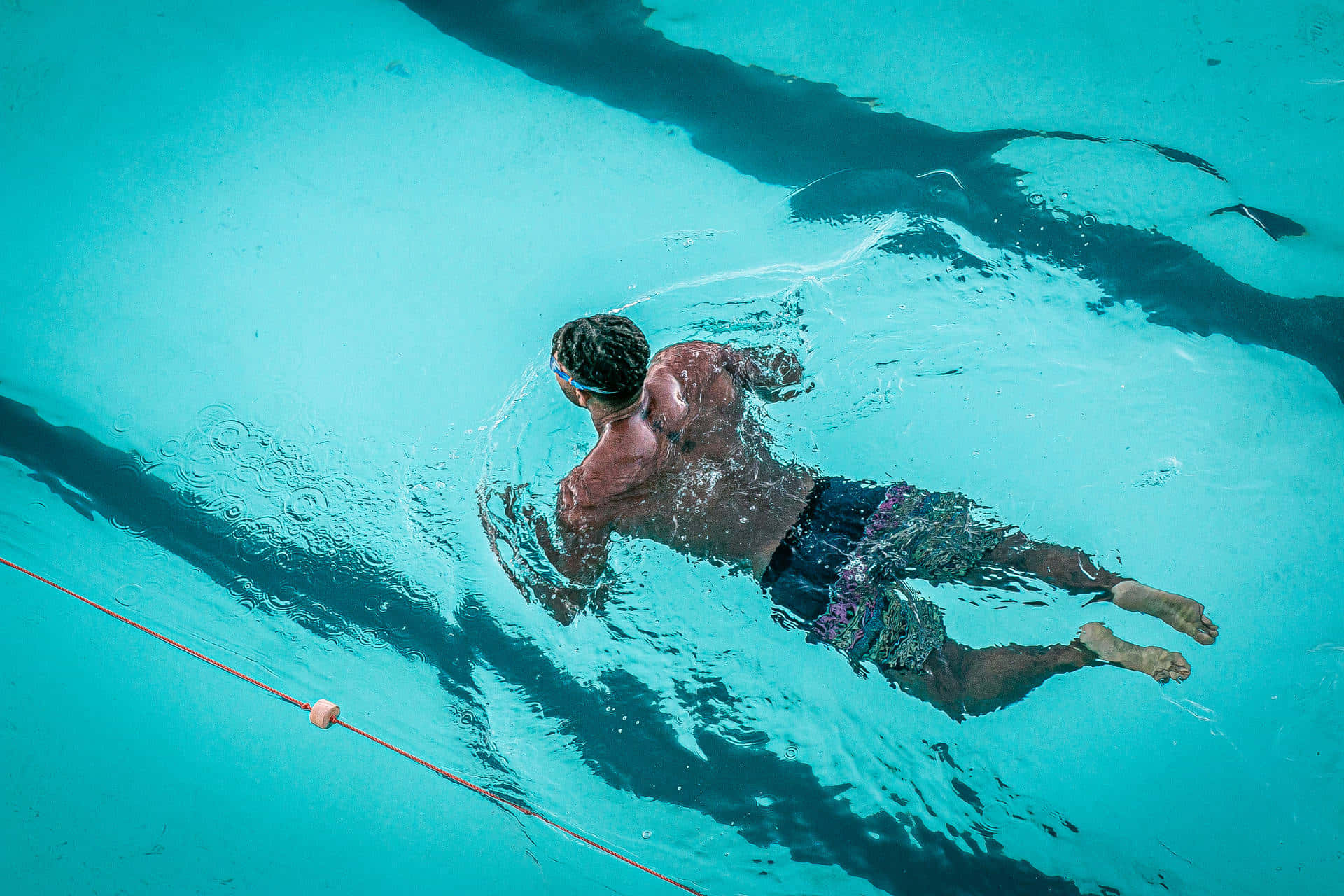A Man Swimming In A Pool Wallpaper