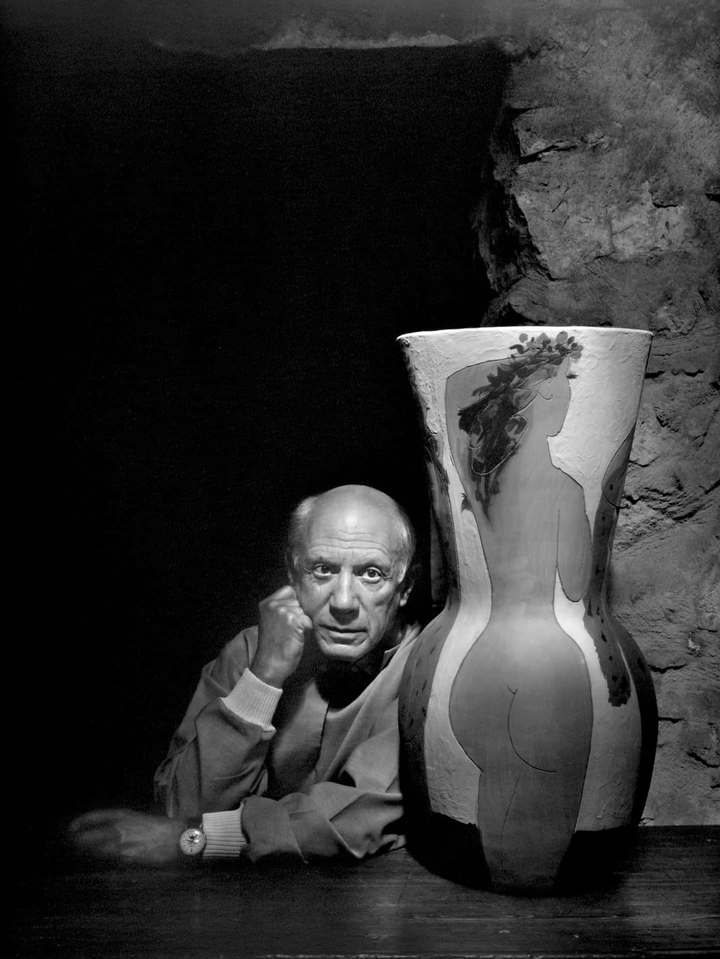 A Man Leaning Against A Vase