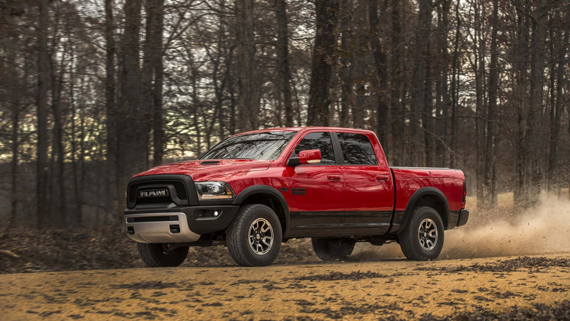 The Red 2019 Ram 1500 Is Driving Down A Dirt Road