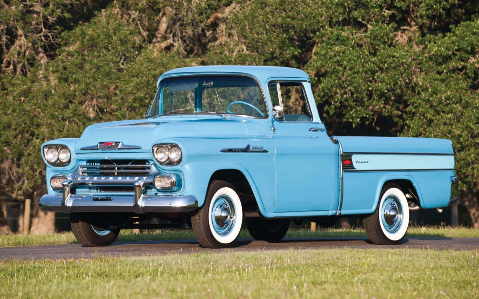 A Blue Classic Truck Is Parked On A Grassy Field