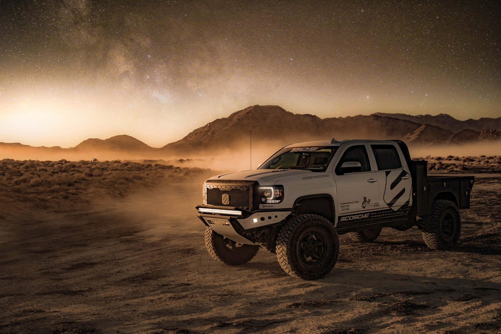 A White Truck In The Desert With A Starry Sky