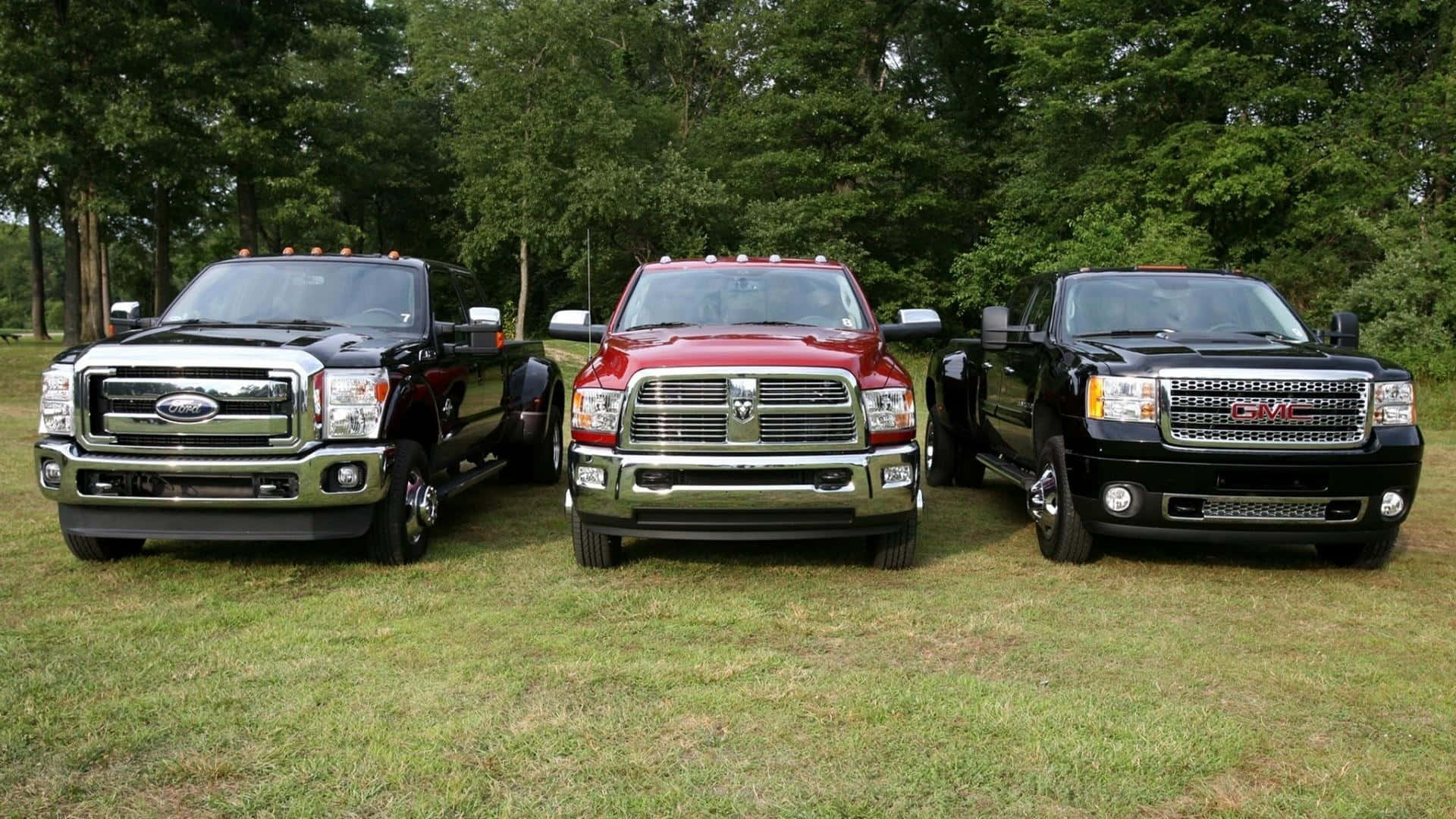 Three Trucks Parked In A Field