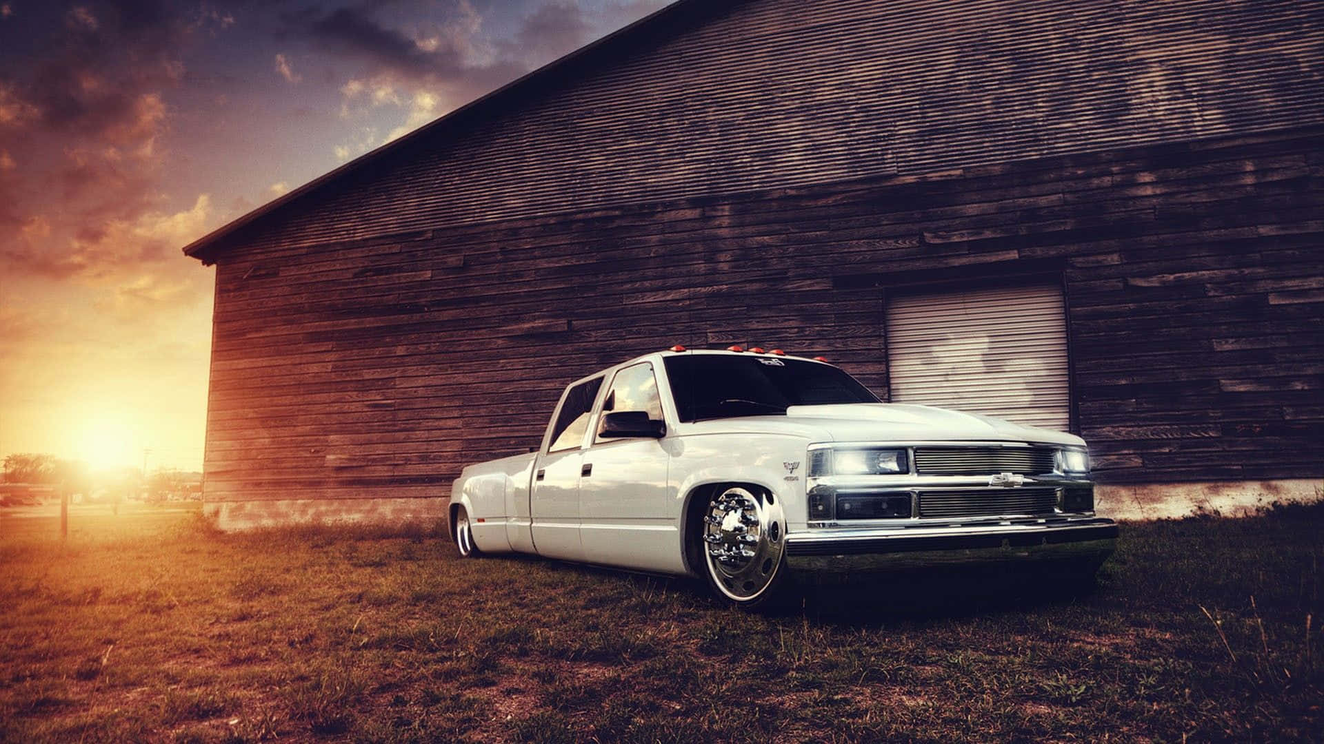 A White Truck Parked In Front Of A Barn