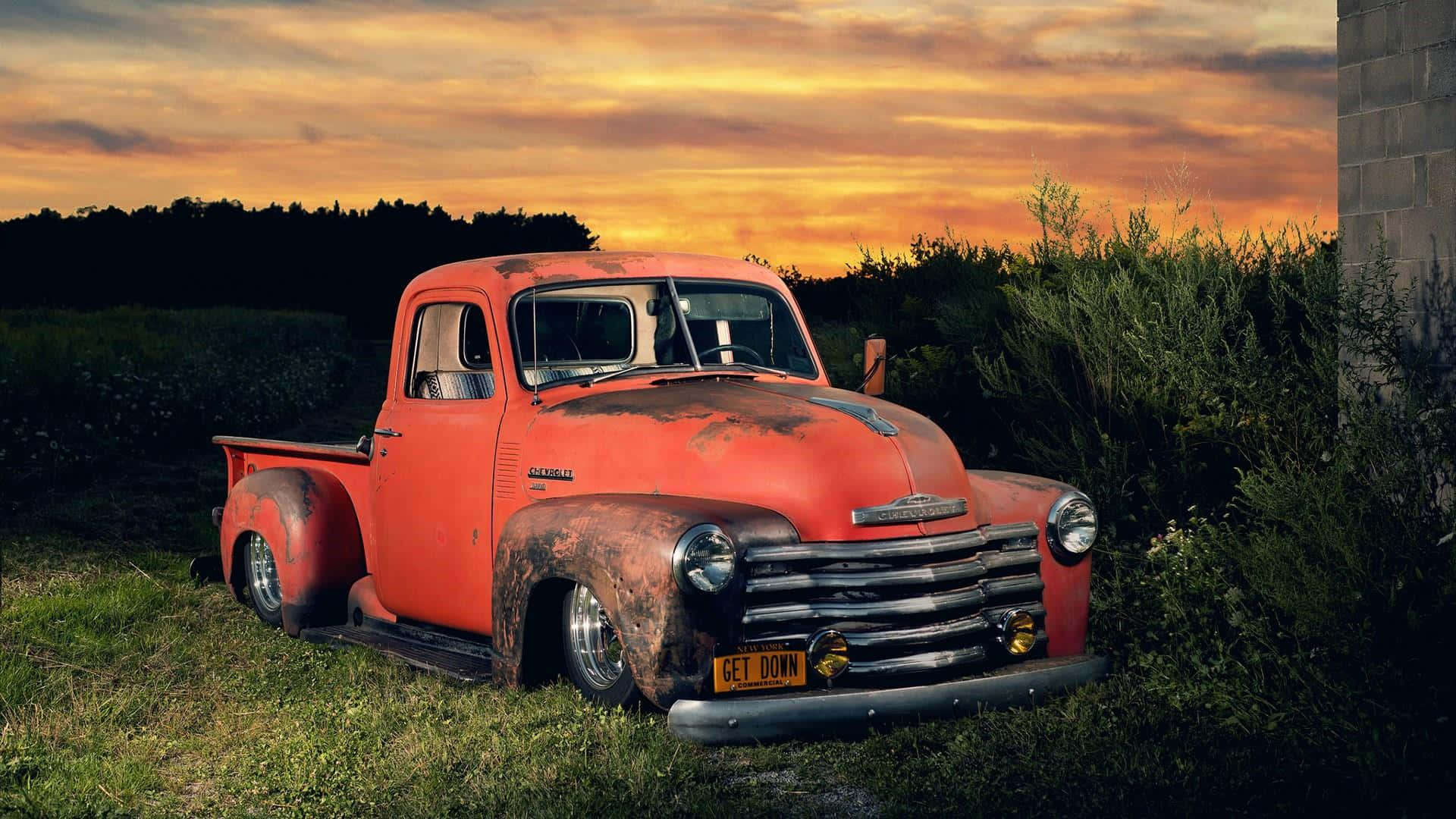 An Old Red Truck In The Grass