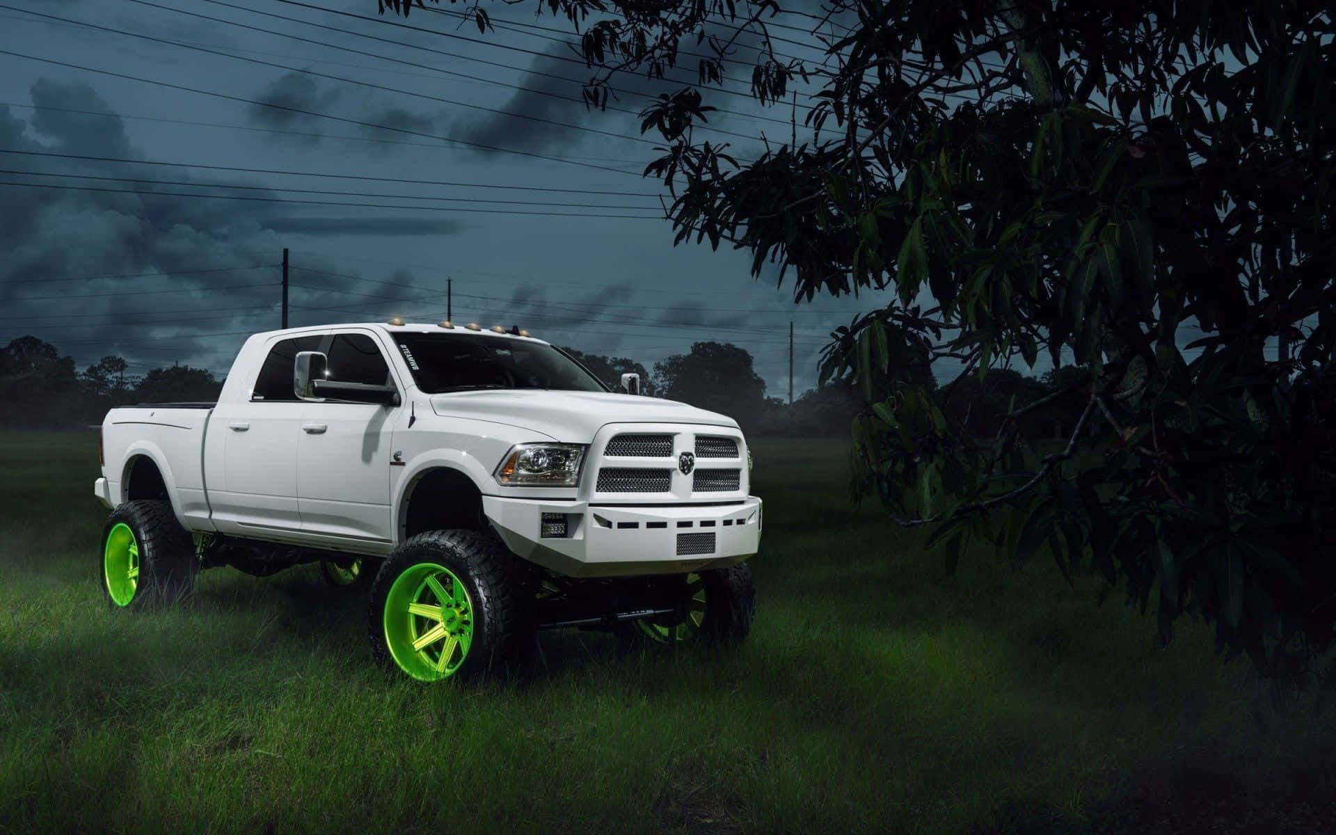 A White Truck With Green Wheels In The Grass