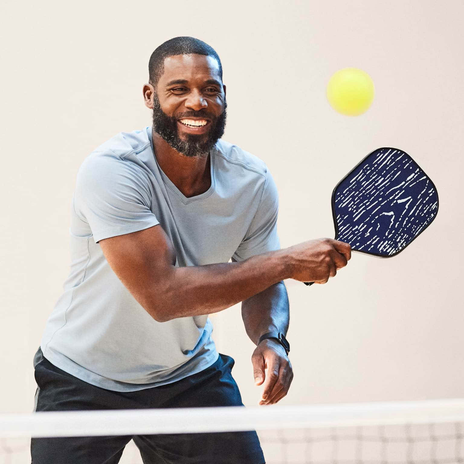 A Man Is Playing Ping Pong With A Racket