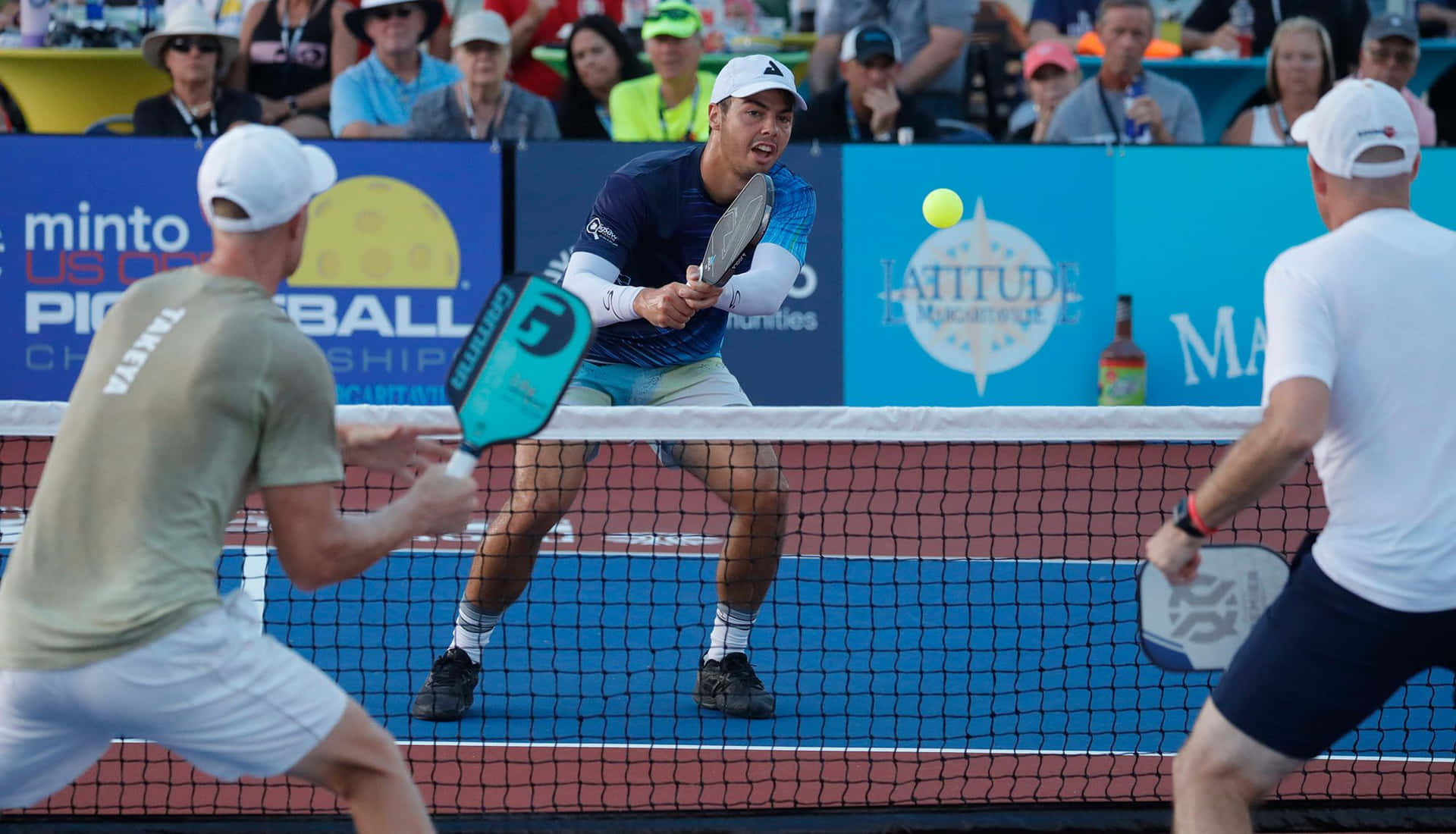 Three Men Playing Tennis In Front Of A Crowd
