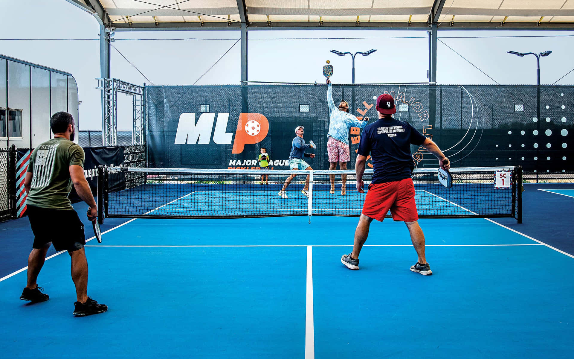 Men Playing Tennis On A Blue Court