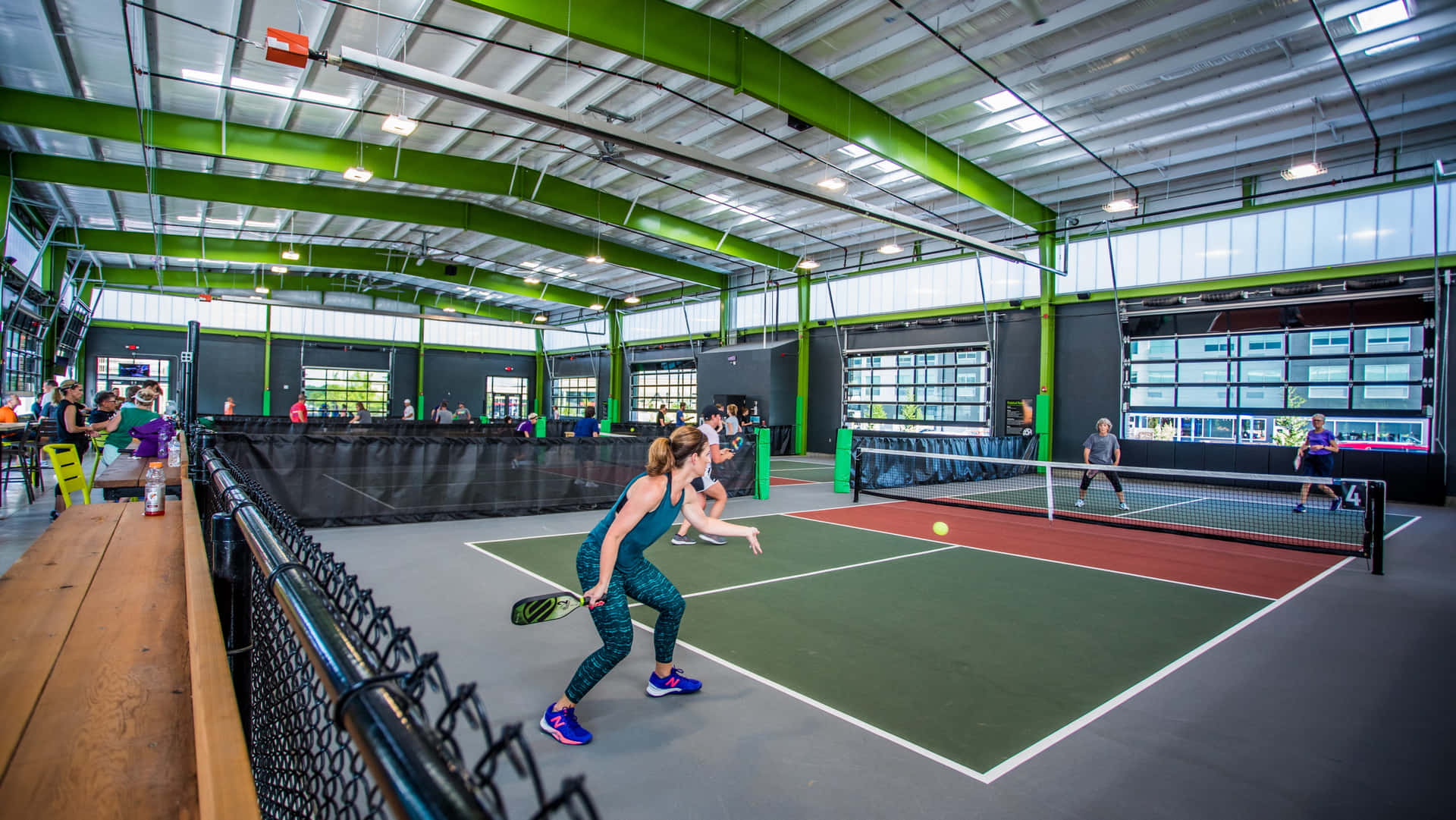A Group Of People Playing Tennis In An Indoor Court
