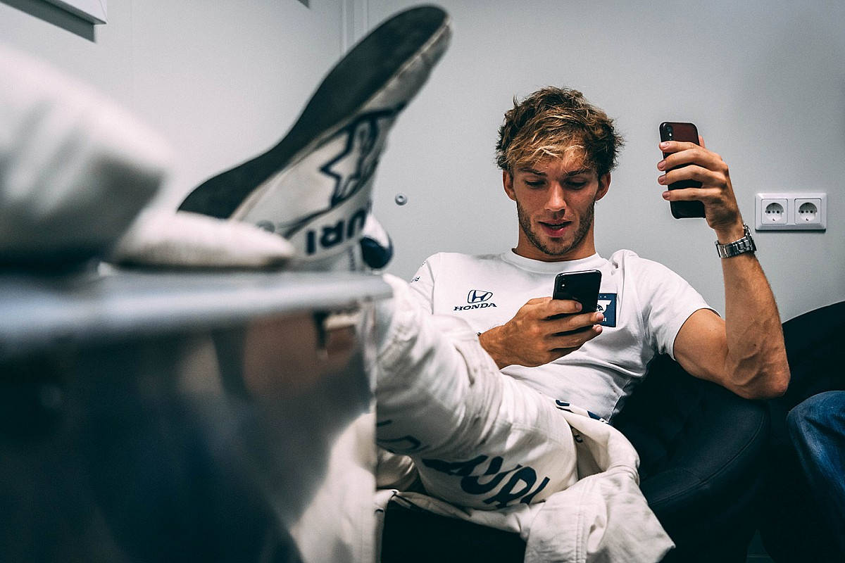 Pierre Gasly leisurely sitting with his leg up, showcasing effortless style. Wallpaper