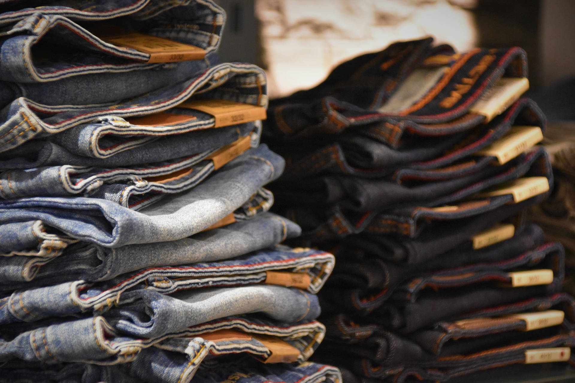 Pile Of Denim Jeans In Different Colors Background
