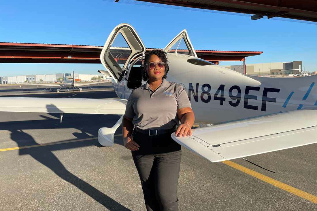 Woman Pilot Standing Next To Airplane