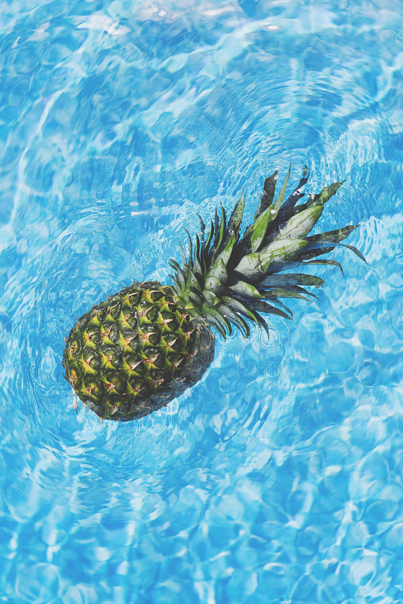 a pineapple floating in a pool