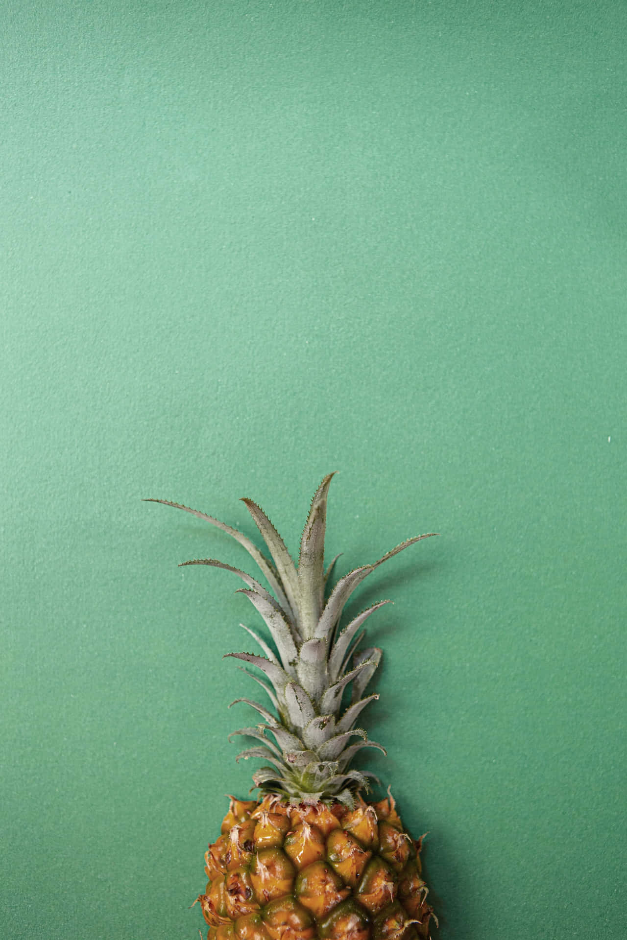Fresh Green Pineapple on a Yellow Background
