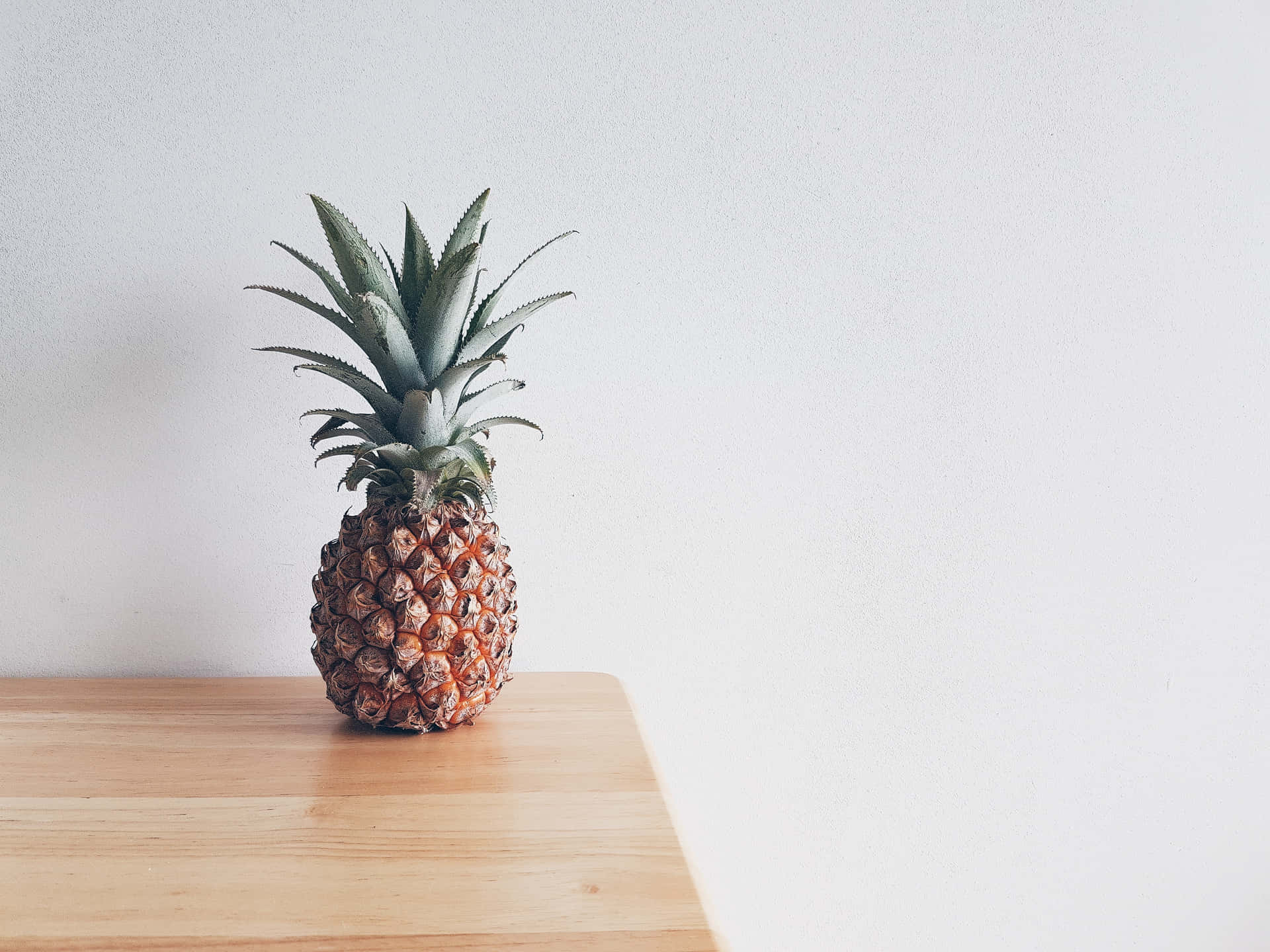 A Pineapple Sitting On A Wooden Table