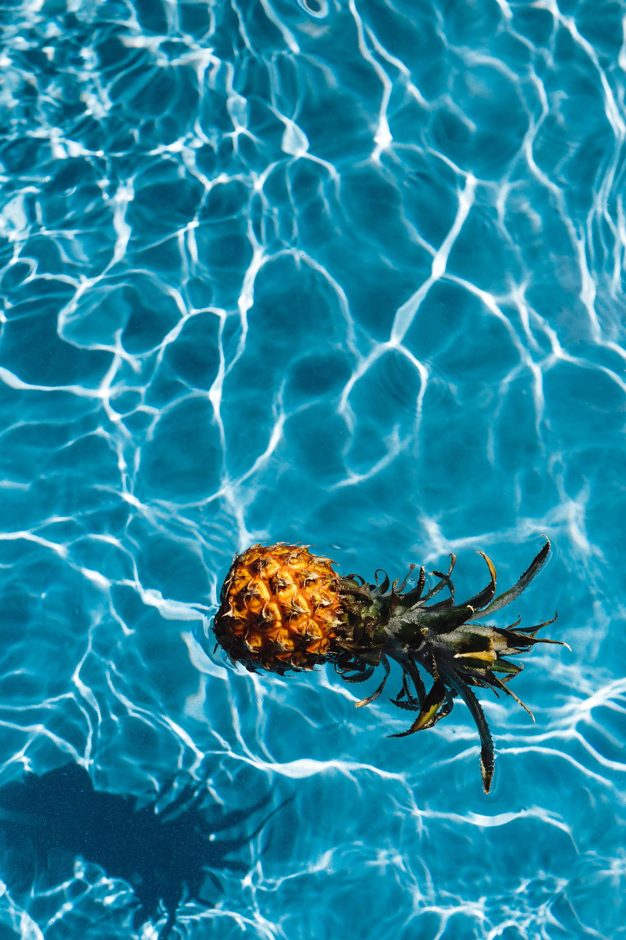 Take a dive into relaxation with this pineapple in the pool. Wallpaper