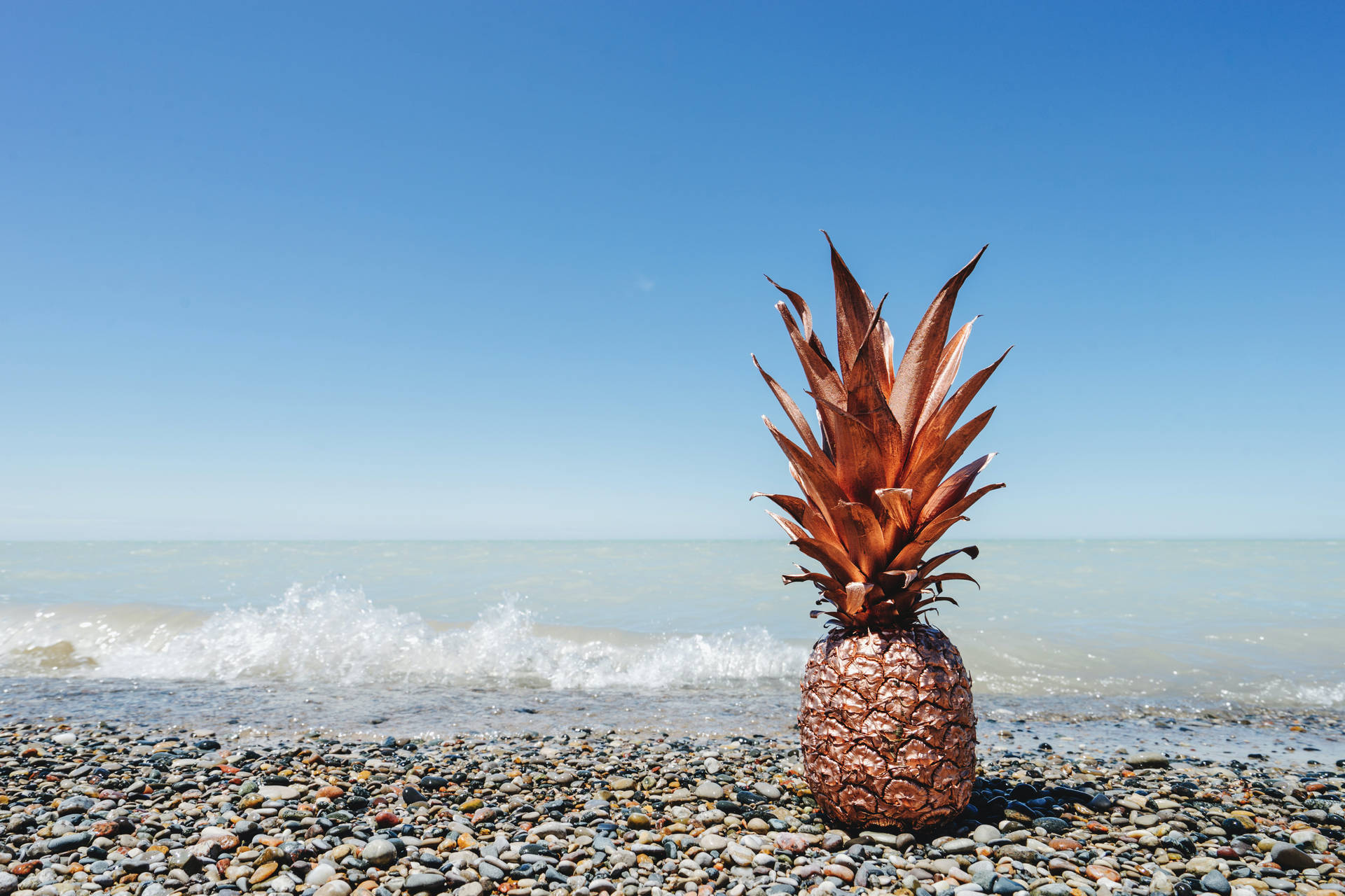 A Pineapple rests atop turbulent rocky waters Wallpaper