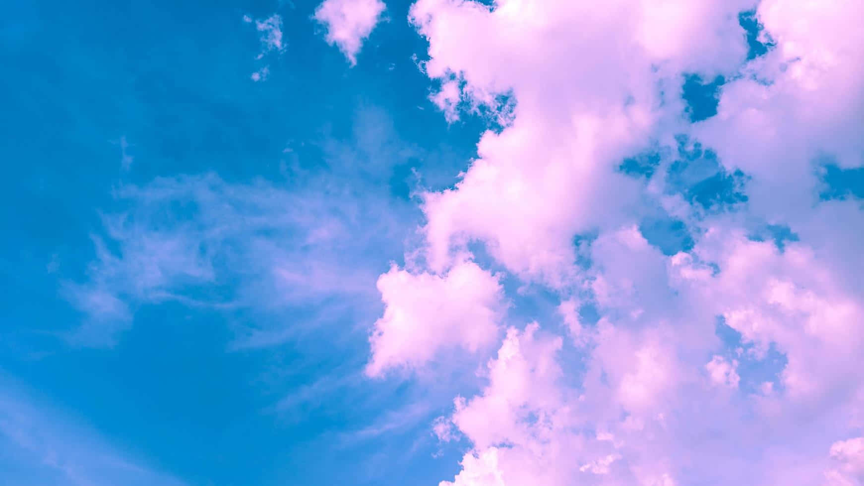 Lyserosa og blå skyer snoede sig sammen i den blå himmel. Wallpaper