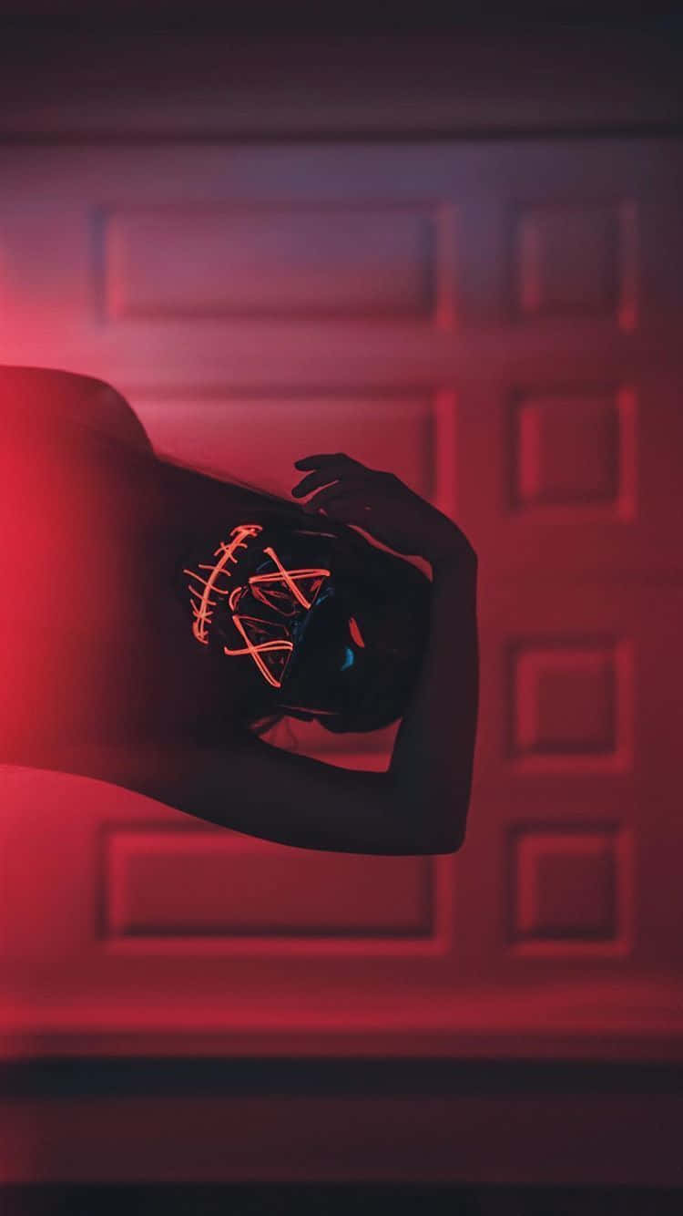 Einefrau Mit Einer Roten Neonmaske Vor Einer Tür Wallpaper