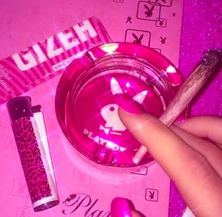 A Person Holding A Pink Ashtray And A Pink Cigarette Wallpaper